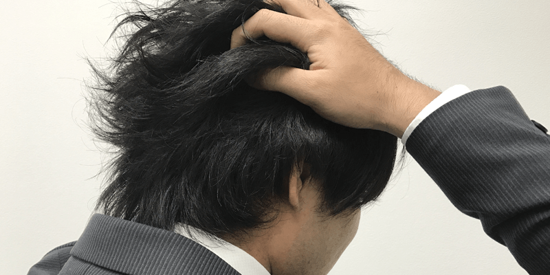 頭を抱えて悩む男性